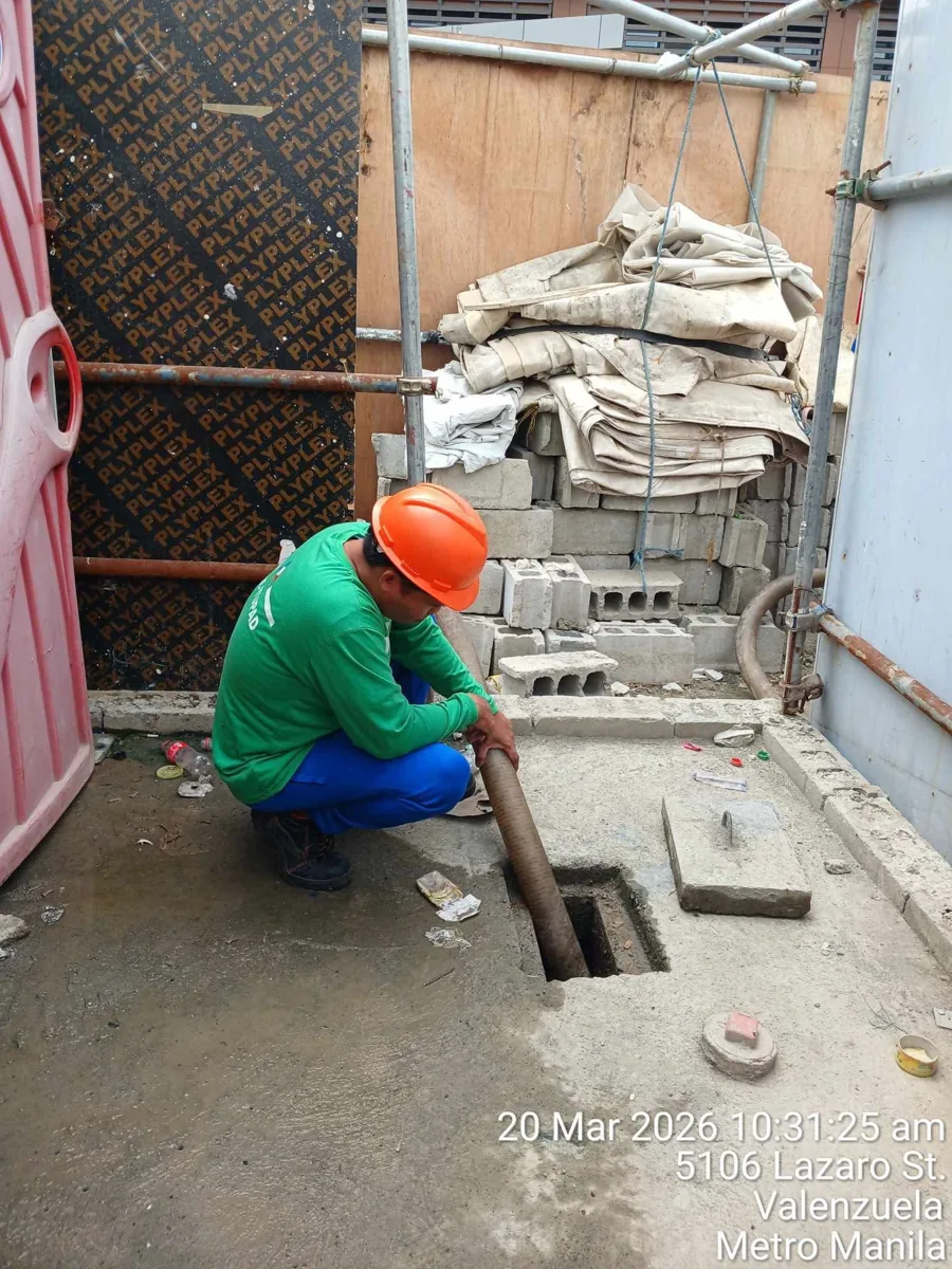 Worker cleaning a drainage or wastewater facility