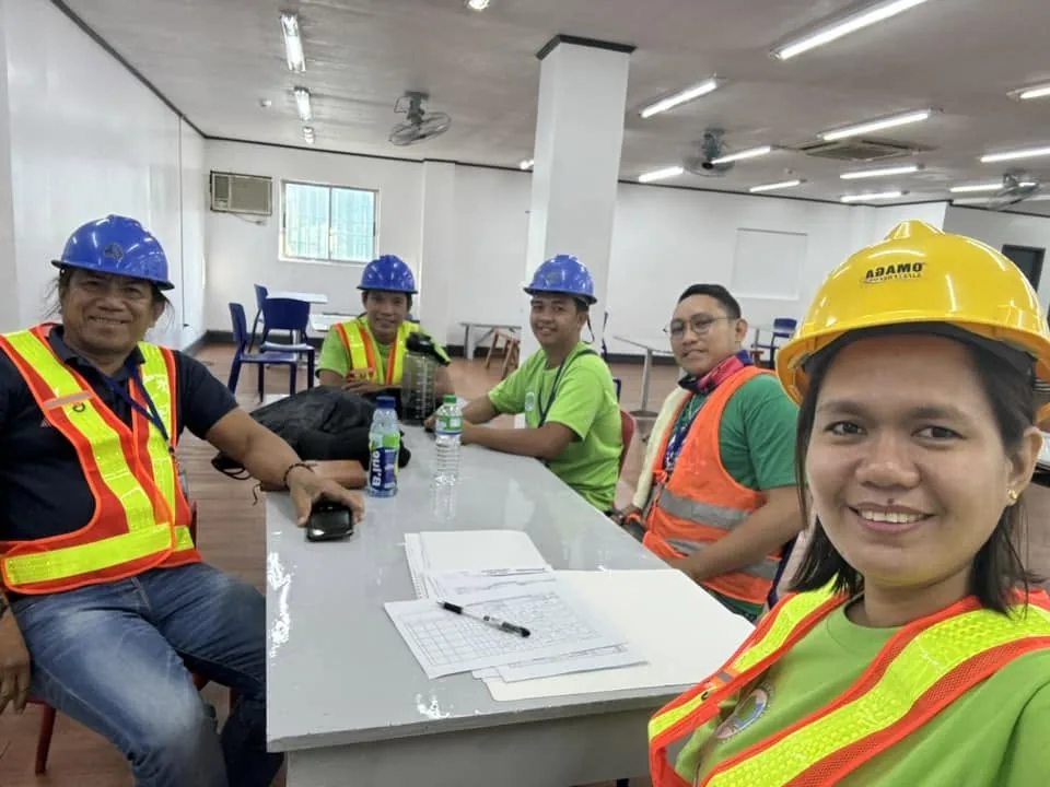 Ecosupreme team members in safety equipment during a site meeting